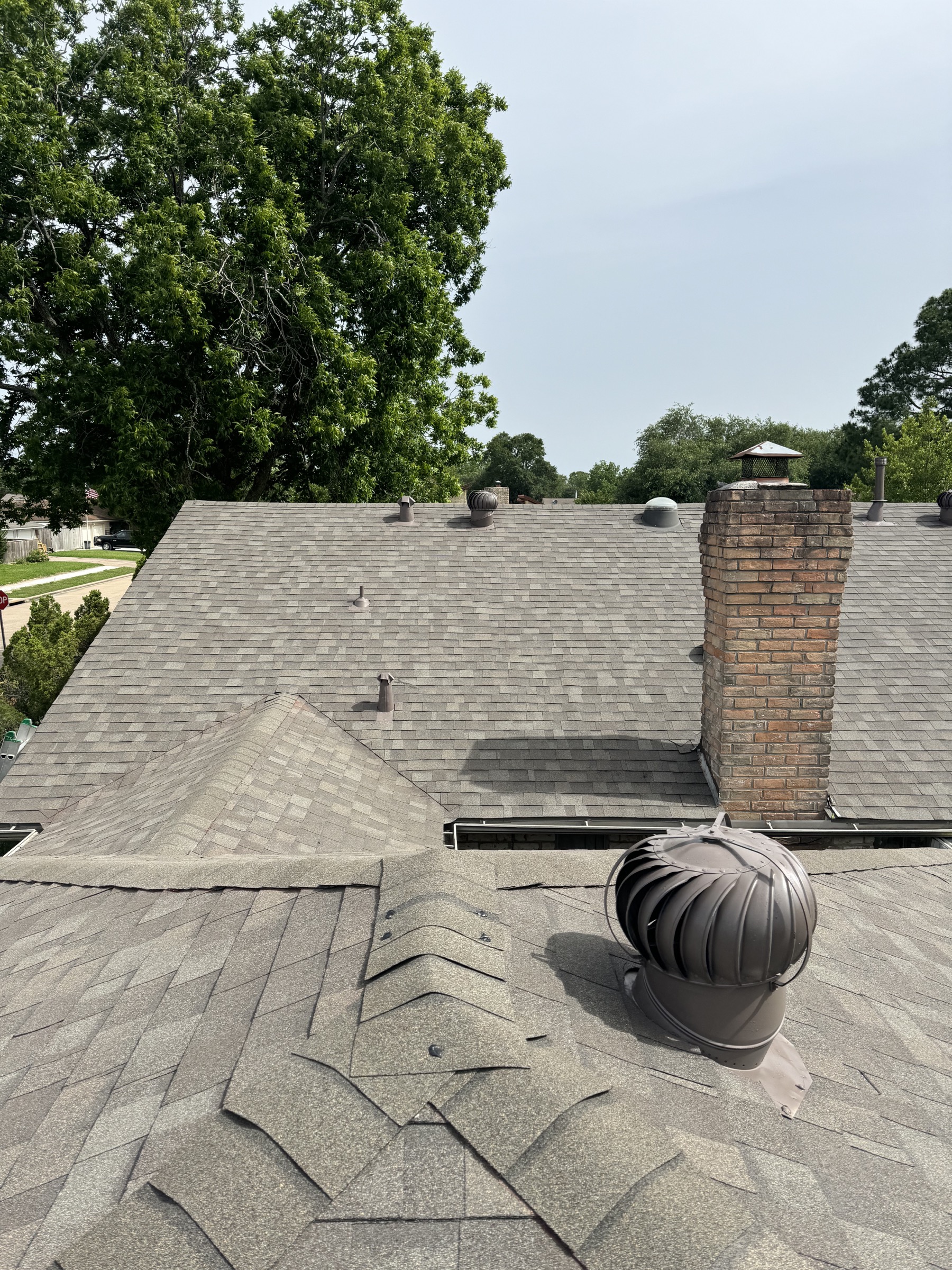 Deer Park roof with chimney, turbine vent, and gray shingles