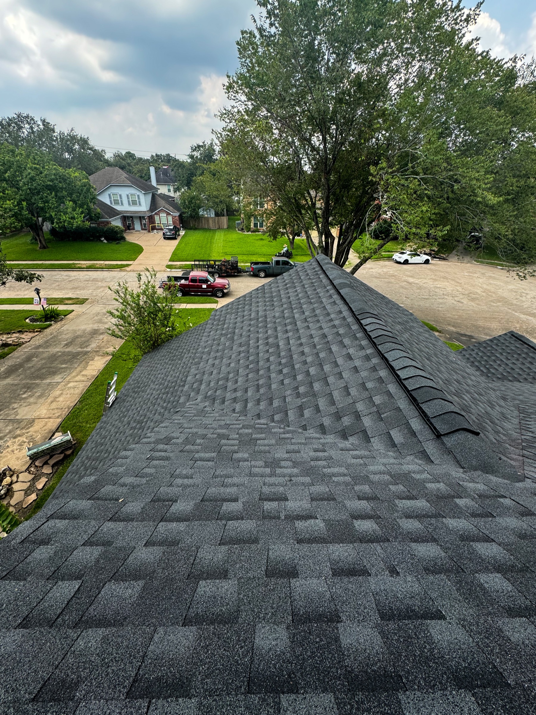 Friendswood roof slope with new gray shingles and neighborhood view