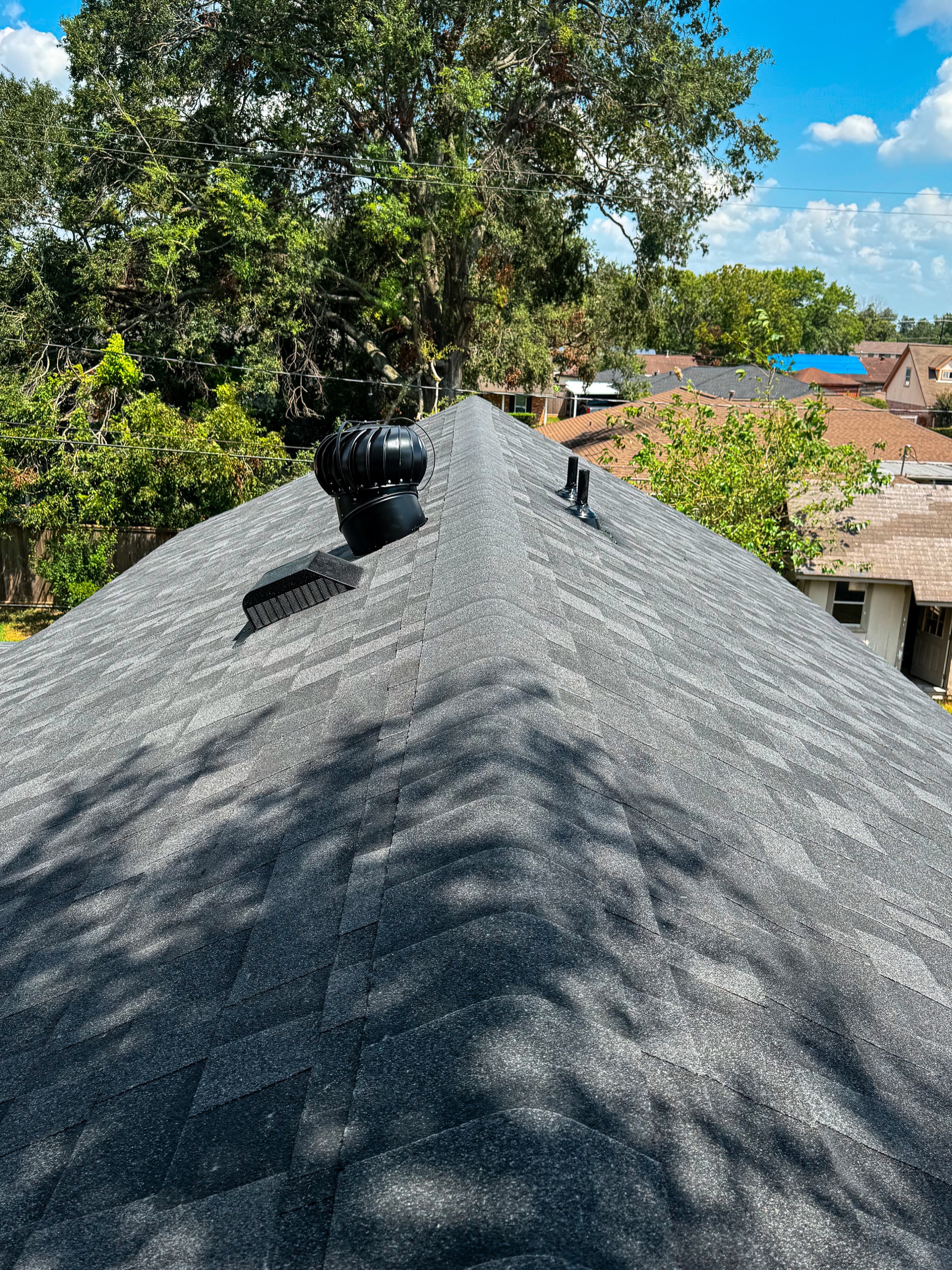 Gray shingle roof ridge on a Pasadena home with ventilation installed